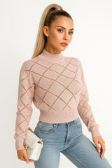 Women's soft pink knit sweater with diamond pattern, styled with light blue jeans and cream handbag
