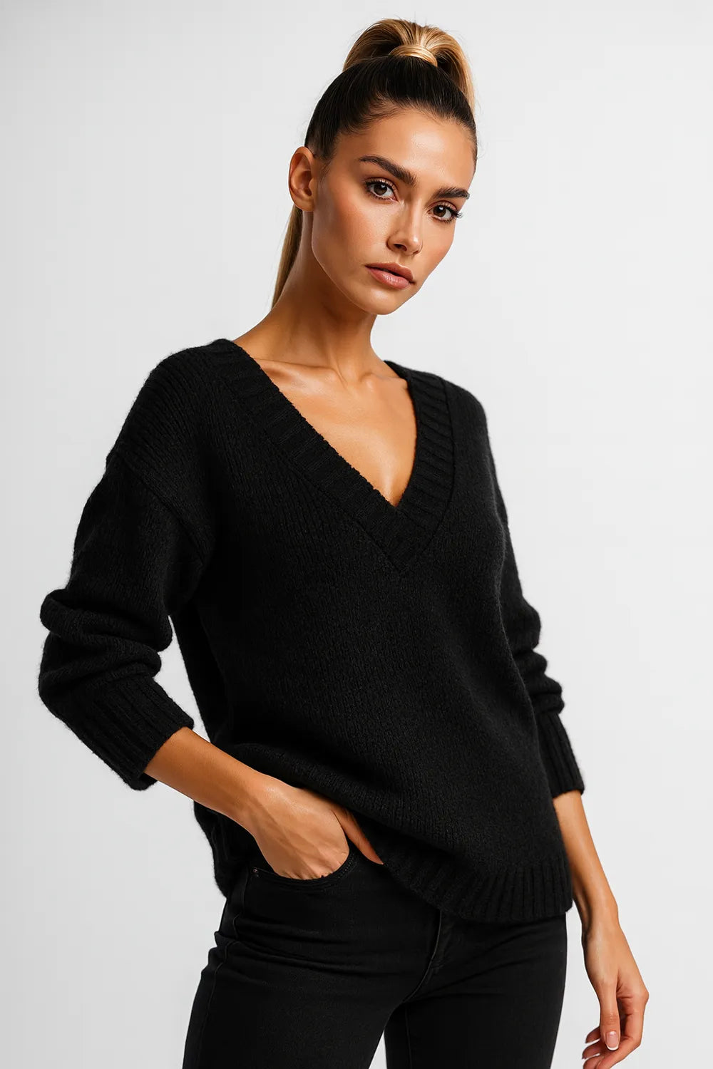 Woman wearing a black V-neck knit sweater with fitted black jeans
